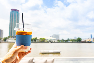 Ice coffee plastic cup with a view of the Chao Phraya River