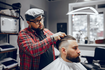Man with a beard. Hairdresser with a client. Man in a red shirt