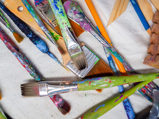 Obraz premium Artist paintbrushes. Flat lay of many artist tools on white fabric.