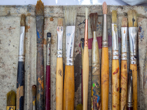 Artist paint brush set. Flat lay of many artist tools in calico paint brush holder.