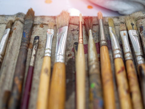 Artist paint brush set. Close-up many artist tools in calico paint brush holder.