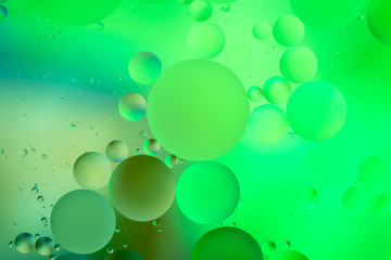bright oily drops in water with colorful background, close-up 