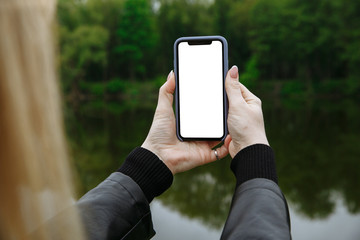 girl holds a phone in her hands and takes pictures