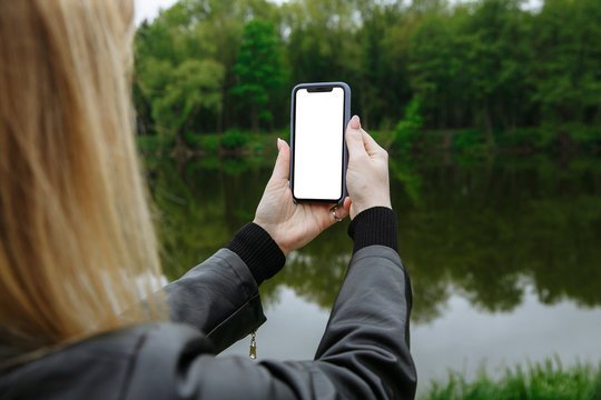 girl holds a phone in her hands and takes pictures