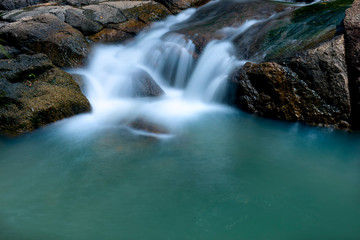 Fototapeta premium Close up of Magical stream in the rainforest with soft flowing water like wool flowing through the cliff