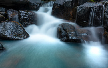 Close up of Magical stream in the rainforest with soft flowing water like wool flowing through the cliff