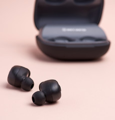 black wireless little earphones and a charging box
