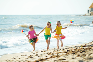 Children at sea. Little girls run on the sea on the waves. 