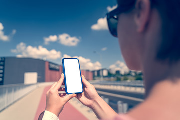 Woman holding smartphone with blank screen.	