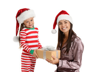 Woman and her little daughter with Christmas gift on white background