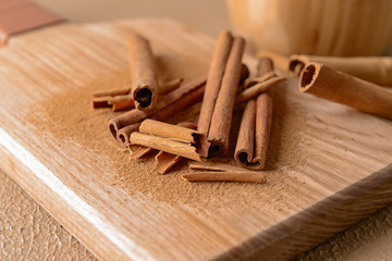 Aromatic cinnamon sticks on wooden board, closeup