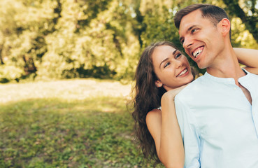Outdoor portrait of romantic couple in love dating outdoors at the park on a sunny day. Happy couple in love embracing each other, looking with love having eyes full of happiness. Date day. Valentine