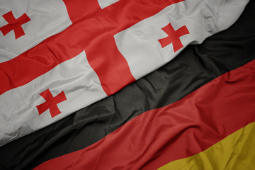 Fototapeta premium waving colorful flag of germany and national flag of georgia.