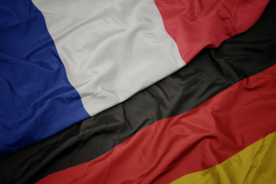 waving colorful flag of germany and national flag of france.
