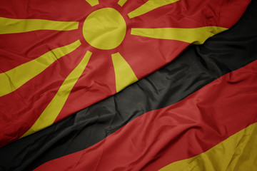 waving colorful flag of germany and national flag of macedonia.