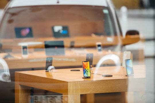 STRASBOURG, FRANCE - NOV 3, 2017: Latest Apple iPhone X and wireless charging dock AirPower goes on sale in Apple Store worldwide - reflection of street in glass facade with phones inside