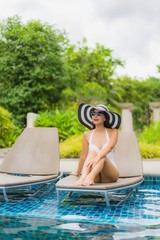 Portrait beautiful young asian woman smile happy relax around swimming pool in hotel resort