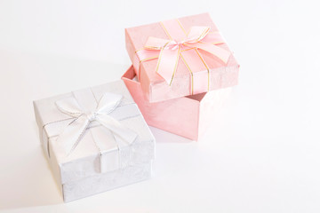 Two decorative holiday gift boxes with ribbon bow for congratulations, surprise, presentation in white and pink on a white background