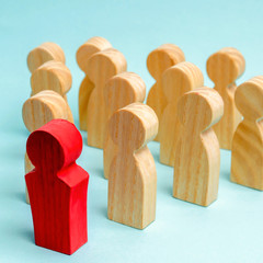 Wooden figures of people. The boss of the business team indicates the direction of movement to the...