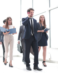 serious business man talking on smartphone while standing in office