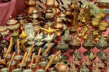 Naklejka premium Turkish copper coffee pots and cups with ornaments on a counter in a Turkish bazaar