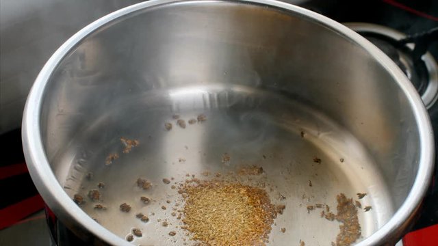 Chef adding masala in a hot pot while preparing vegetable curry. 
