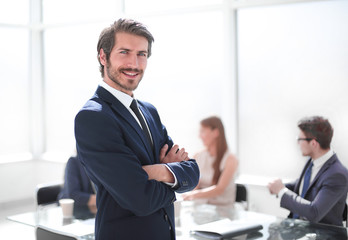 smiling young businessman standing in his office