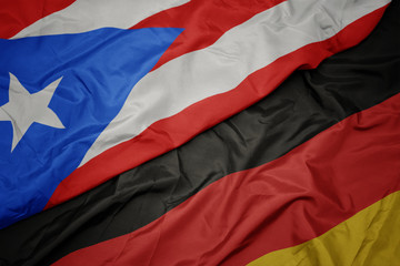 waving colorful flag of germany and national flag of puerto rico.