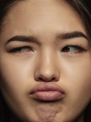 Close up portrait of young and emotional chinese woman. Highly detail photoshot of female model with well-kept skin and bright facial expression. Concept of human emotions. Thinking, looking at side.