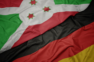 waving colorful flag of germany and national flag of burundi.
