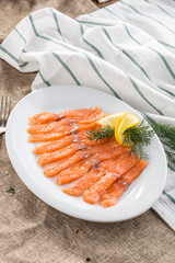 slices of smoked salmon on white plate on tablecloth