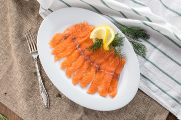 slices of smoked salmon on white plate on tablecloth