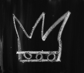Crown drawn on black chalkboard, blackboard texture and background