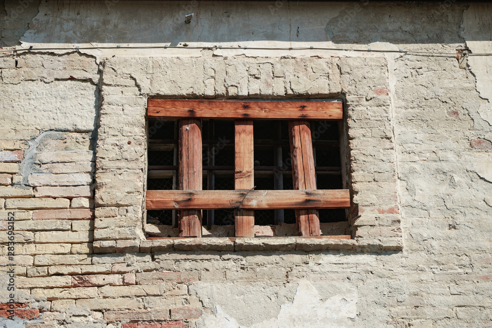 Aufkleber old window of a brick building clogged with boards.