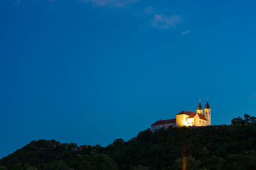 Obraz premium Tihany Benedictine abbey in yellow light at the blue hour in Tihany, Hungary