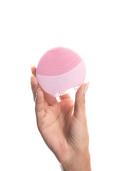 cropped view of young woman holding facial cleansing brush isolated on white