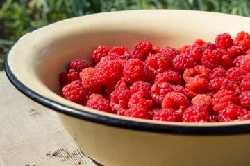 Fresh raspberries in a plate. Background.