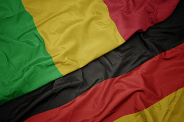 waving colorful flag of germany and national flag of mali.