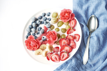 plate with vegan slices of frozen fruits: arbuk, blueberries, blueberries, banana with yogurt