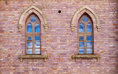Brick wall with two windows in the Gothic style. Gothic style in architecture