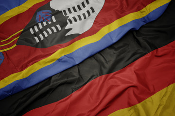 waving colorful flag of germany and national flag of swaziland.
