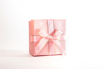 One decorative holiday gift box with ribbon bow for congratulations, surprise, pink present on white background with copy space