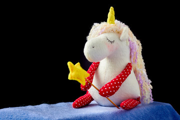Soft toy of unicorn girl sitting. Children's interior fabric toy for kids room decor