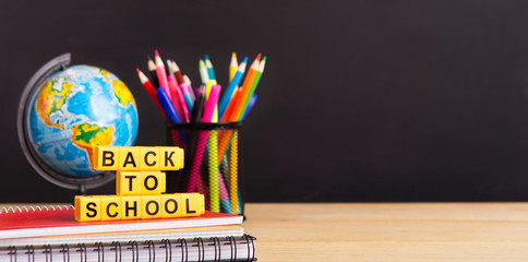 World globe and stationery with text in front of chalkboard