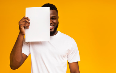 African man covering half of his face with clean paper