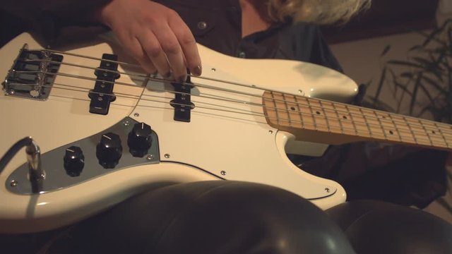 Home recording studio. 2 Shots.  1. Close-up. Camera moves from left to right. Female hand plugs the plug of audio cable into bass connector.  2. Camera moves from left to right.