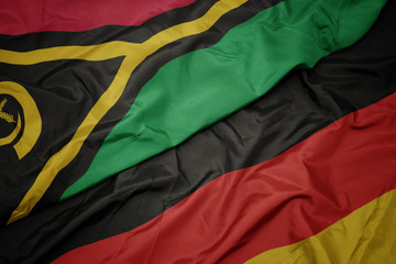 waving colorful flag of germany and national flag of Vanuatu.