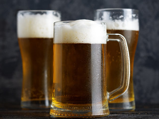 Beer mug and beer glasses on a dark background close-up