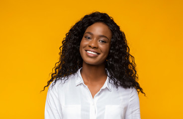 Young smiling african american woman over yellow background