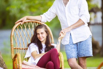 Happy couple at barbecue dinner on sunset time. Having meal together outdoor in a forest glade....